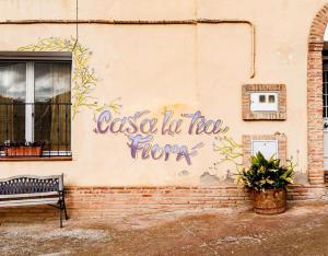 un edificio con graffiti en el costado con un banco en Casa Rural La Tia Flora, en Santa Cruz de Nogueras