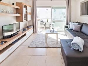 a living room with a couch and a tv at Apartment Panorama Rocha Capri in Portimão