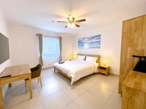 a bedroom with a bed and a ceiling fan at Bon Bini Suites in Oranjestad