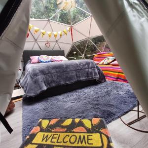 - une chambre avec un lit dans une tente dans l'établissement Fantasia Glamping, à Bogotá