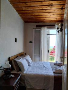 een slaapkamer met een bed en een groot raam bij Traditional house in Ratzaklíon