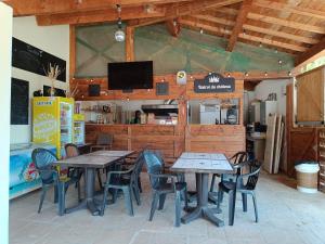 a restaurant with two tables and chairs and a tv at Le soleil d Eugènie appartement dans résidence avec Piscine commune près de Carcassonne in Olonzac