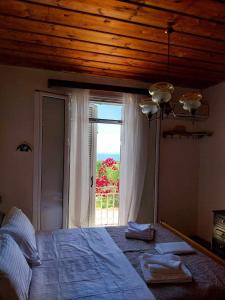 een slaapkamer met een bed en een groot raam bij Traditional house in Ratzaklíon