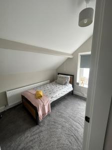 Habitación pequeña con cama y ventana en Eddies Lodge & Spa 3 bedroom cottage, en Dungiven