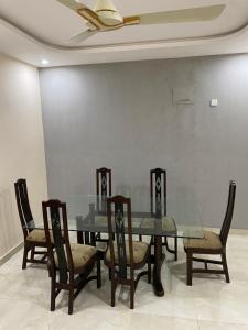 a dining room with a glass table and chairs at Private room in Islamabad