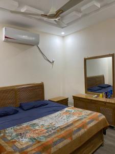um quarto com uma cama, um espelho e uma ventoinha em Private room em Islamabad