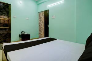 a bedroom with a white bed in a room at OYO Flagship Kamla P Guest House in Varanasi