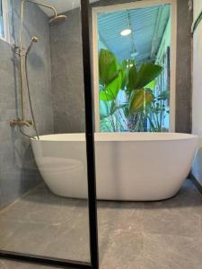 a bath tub in a bathroom with a plant at Entire home and private beach in Phu Yen, Vietnam in Tuy An
