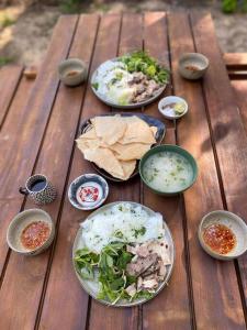 a wooden table with plates of food on it at Entire home and private beach in Phu Yen, Vietnam in Tuy An