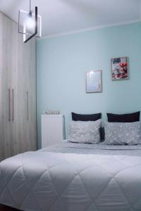 ein Schlafzimmer mit einem großen Bett mit blauen Wänden in der Unterkunft Agis home in Ágios Rókkos