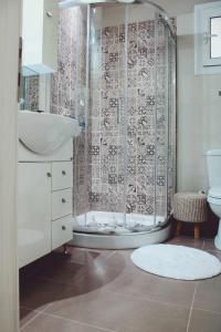 een badkamer met een douche, een wastafel en een toilet bij Agis home in Ágios Rókkos