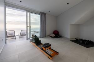 sala de estar con cinta de correr y ventana grande en Villa Pérola, en Calheta