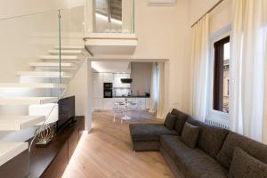 un salon avec un canapé et un escalier dans l'établissement Dolce Vita Apartament, à Florence
