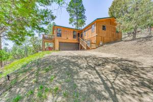 a house on top of a hill with trees at Peaceful Ruidoso Cabin Hot Tub, Mountain Views! in Ruidoso