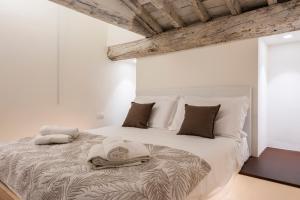 une chambre avec un grand lit avec des serviettes dessus dans l'établissement Dolce Vita Apartament, à Florence