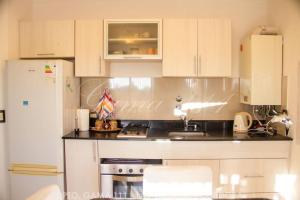 a kitchen with white cabinets and a sink and a refrigerator at Departamento GAMA 111. in Las Varillas