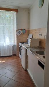 a kitchen with a stove and a sink and a window at Gästehaus Fogarasch in Făgăraş