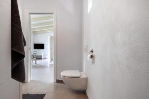 een witte badkamer met een toilet en een hal bij Ca’ Scaì Agrifugium Elià in Tignale +13 foto's