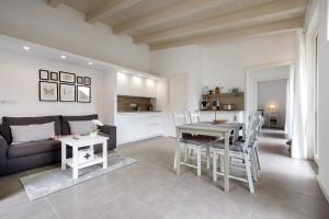 een keuken en woonkamer met een tafel en een bank bij Ca’ Scaì Agrifugium Elià in Tignale