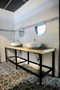 a bathroom with two sinks and two mirrors at Asha Hostel in Fortuna