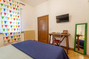 1 dormitorio con cama, mesa y espejo en Maxi Paradiso, en Torricella