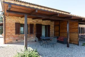 eine Terrasse mit einem Tisch und Stühlen sowie ein Gebäude in der Unterkunft San Lorenzo Agriturismo in Buonconvento