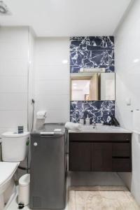 a bathroom with a sink and a toilet and a mirror at Chic Apartment Cosy Stay in Casablanca