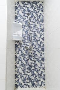 a shower in a bathroom with blue and white tiles at Chic Apartment Cosy Stay in Casablanca