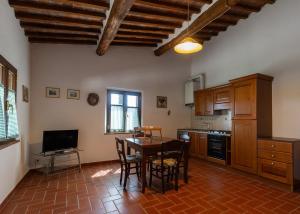 cocina con mesa y sillas y TV en San Lorenzo Agriturismo en Buonconvento