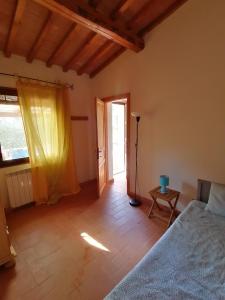 1 dormitorio con cama, mesa y ventana en Agriturismo Campolungo, en Sant'Ermo