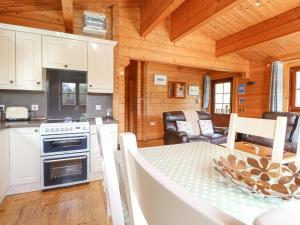 的住宿－Heron Lodge，小屋内的厨房和用餐室配有桌子