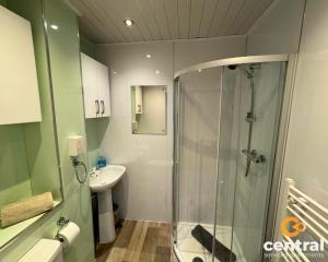 y baño con ducha y lavamanos. en 2 Bedroom Apartment by Central Serviced Apartments - Ground Floor - Monthly & Weekly Bookings Welcome - FREE Street Parking - Close to Centre - 2 Double Beds - WiFi - Smart TV - Fully Equipped - Heating 24-7, en Dundee