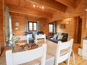 uma sala de estar com mesa e cadeiras em Kingfisher Lodge 