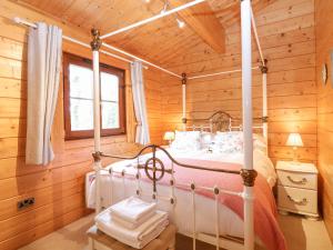 1 dormitorio con 1 cama en una cabaña de madera en Kingfisher Lodge 