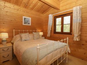 a bedroom with a bed in a log cabin at Wagtail Lodge in Langham