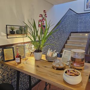 einem Holztisch mit Weingläsern und einer Pflanze darauf in der Unterkunft Sé Velha Exclusive Suite - Authentic Coimbra in Coimbra