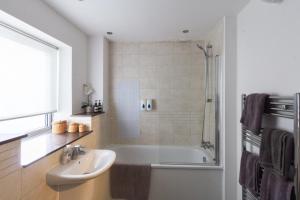 bagno con vasca, lavandino e doccia di Spacious Central Family Apartment a Londra