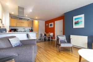 a living room with a couch and a kitchen at Spacious Central Family Apartment in London