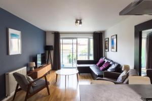a living room with a couch and a tv at Spacious Central Family Apartment in London