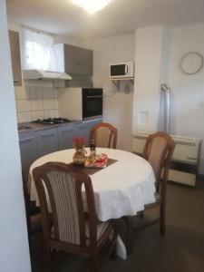 a small kitchen with a table with chairs and a tableablish at Apartman "Vuković" in Bizovac