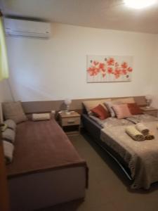um quarto com uma cama e um sofá em Apartman "Vuković" em Bizovac