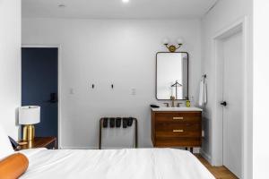una camera da letto con un letto, un comò e uno specchio di DTWN Bangor, Historic Hotel, Coffee Shop in building, Room # 105 a Bangor