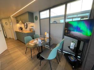 a dining room with a table and chairs and a flat screen tv at Hausboot Fjord Baltica mit Dachterrasse in Barth in Barth