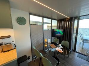 a dining room with a table and chairs and a clock at Hausboot Fjord Baltica mit Dachterrasse in Barth in Barth