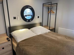 a bedroom with a bed and a round mirror at Hausboot Fjord Baltica mit Dachterrasse in Barth in Barth