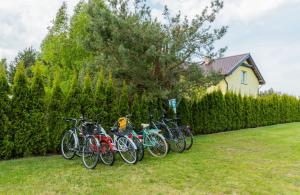 a group of bikes parked next to a fence at Domki CUBA - Komfortowe domki w cichej okolicy in Ostrowo