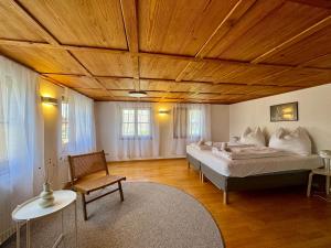een slaapkamer met een groot bed en een houten plafond bij Charmantes Bauernchalet Alois in Dornbirn