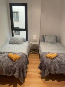 two twin beds in a room with a window at Apartamento en Olvan 3 - ALBERGA in Olvan