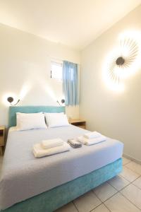 ein Schlafzimmer mit einem Bett mit zwei Handtüchern darauf in der Unterkunft Tropical Beach A1 in Kalamaki