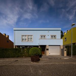 une maison blanche avec un toit bleu dans l'établissement Outeiro Villas Resort, à Barcelos